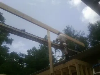 Carpenter setting a ridge beam over a new addition frame — Ice Dam Removal by Roofing Brothers in Sherman Oaks